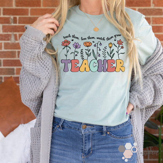 Woman wearing Teach Love Grow Tee in heather dusty blue